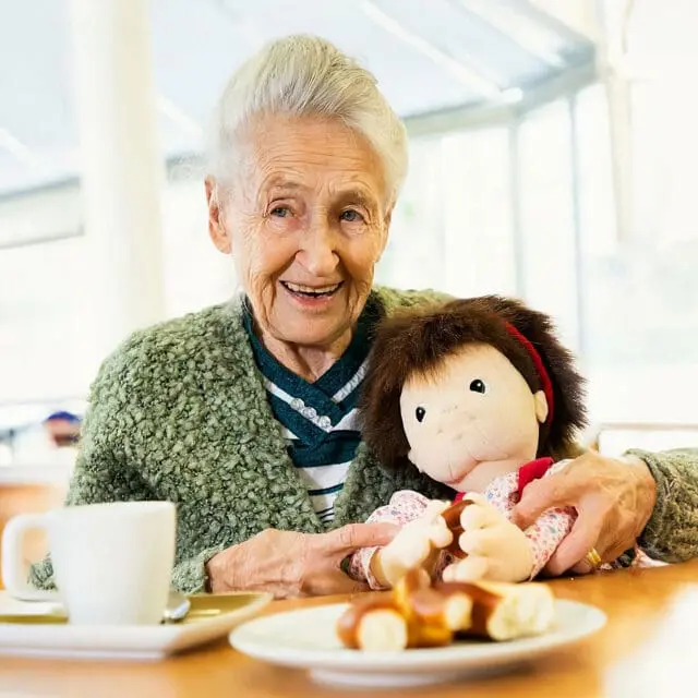 Care resident with empathy doll for dementia